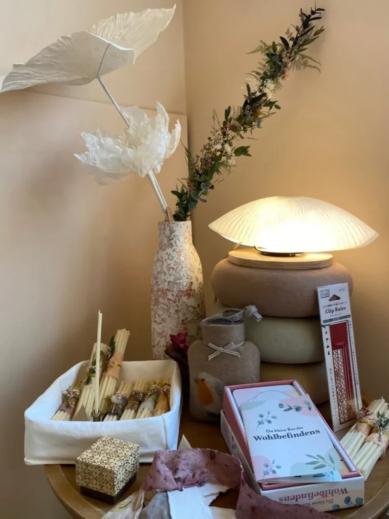 Eingeschaltete Papierlampe neben einer Vase mit getrockneten Gräsern
