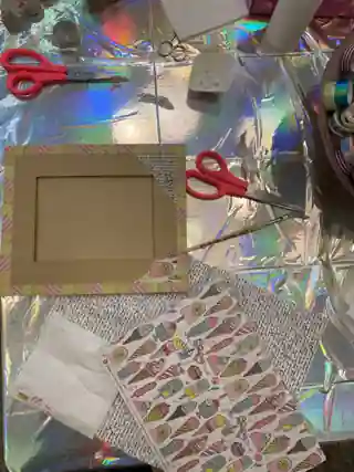 Basteltisch von oben mit Rahmen, Washi-Tape und Papieren