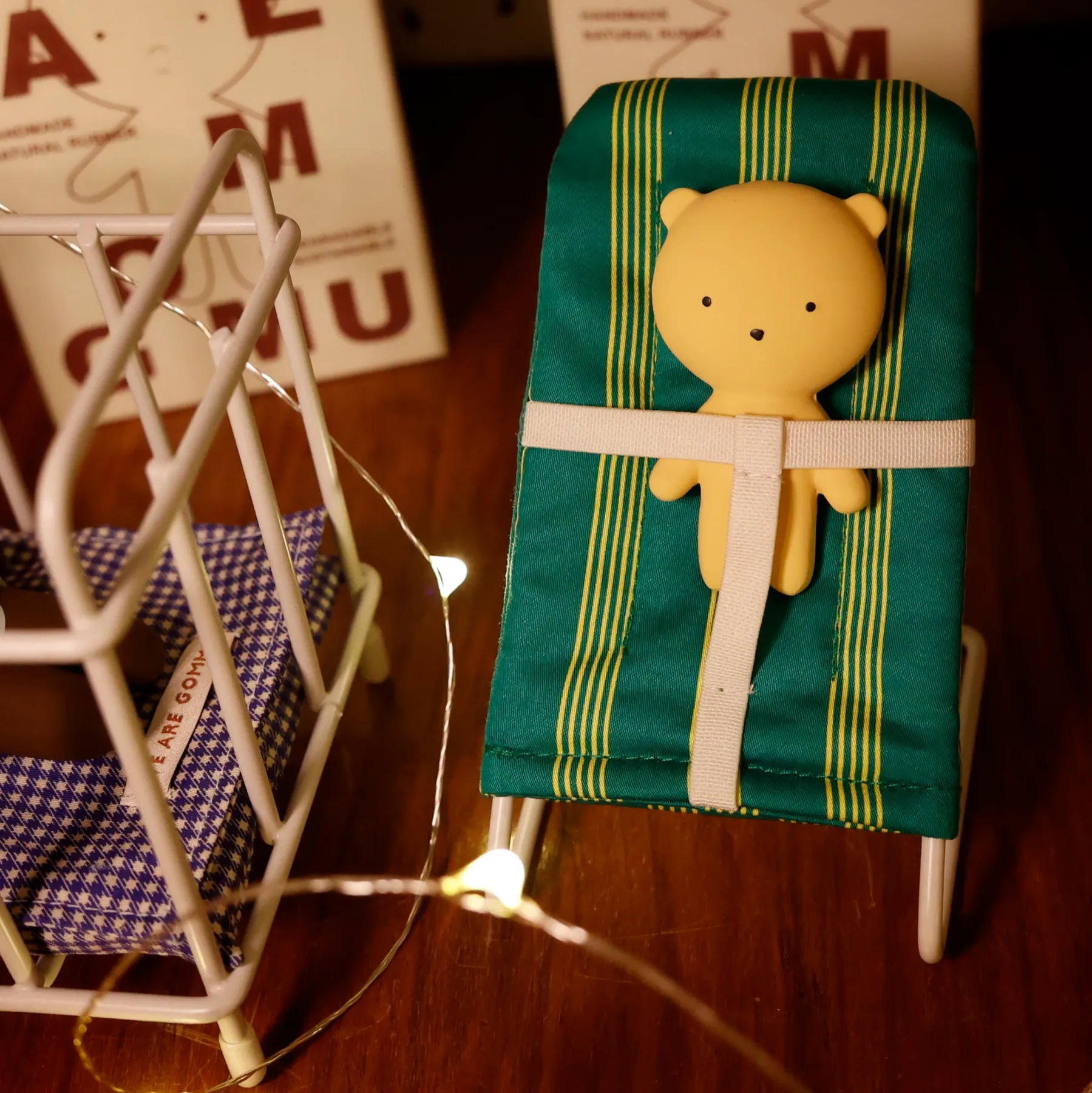 Kleiner gelber Teddy auf grün gestreiftem Geschenk