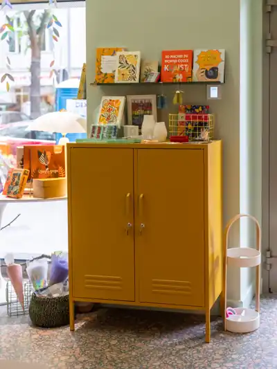 Senfgelber Metallschrank mit Karten und Papeterie im Schaufenster von L' Atelier Papier