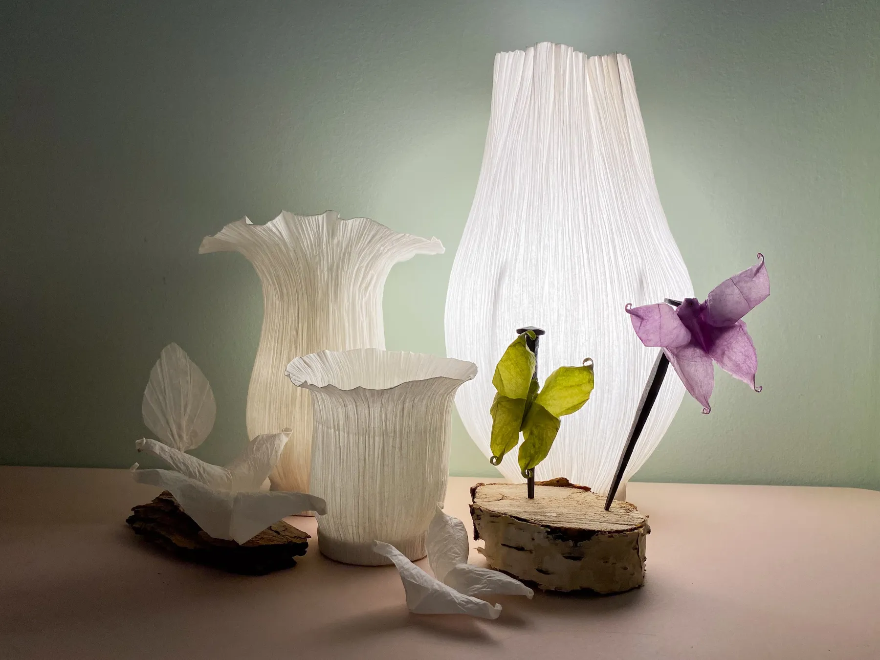 Weiße gefaltete Papierleuchte von Charlot & Cie mit Papierblüten und einem Schmetterling auf einem Holzstück