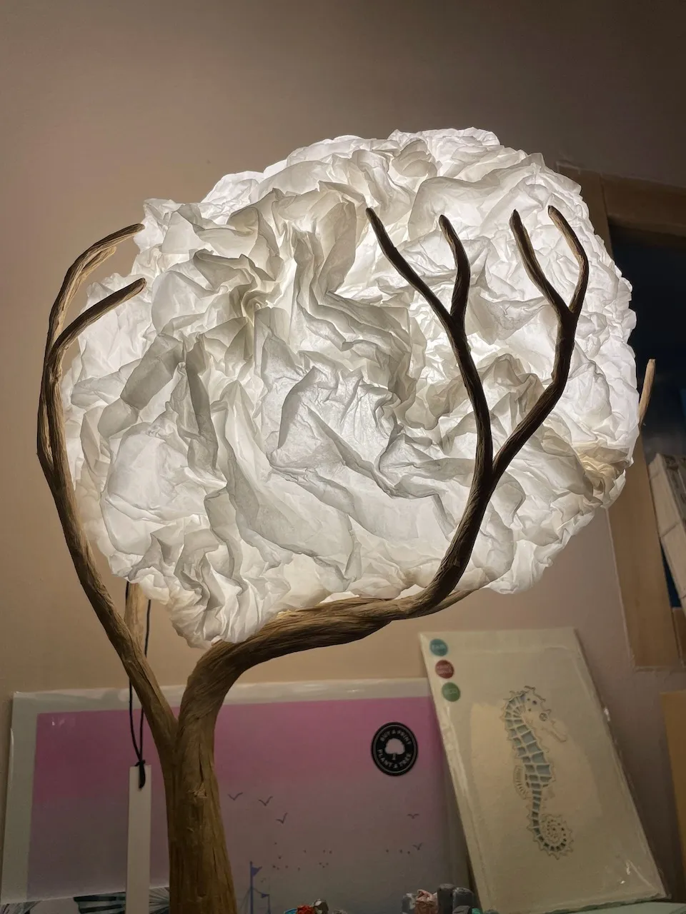 Stehleuchte mit Papierwolke auf einem Astgestell im Verkaufsraum von L' Atelier Papier