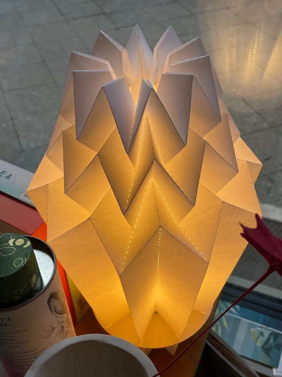 Origami-Tischleuchte aus Papier mit scharfen Falten, warmes Licht