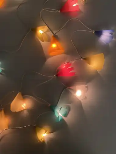 Leuchtende Lichterkette mit orangen Papierlampions